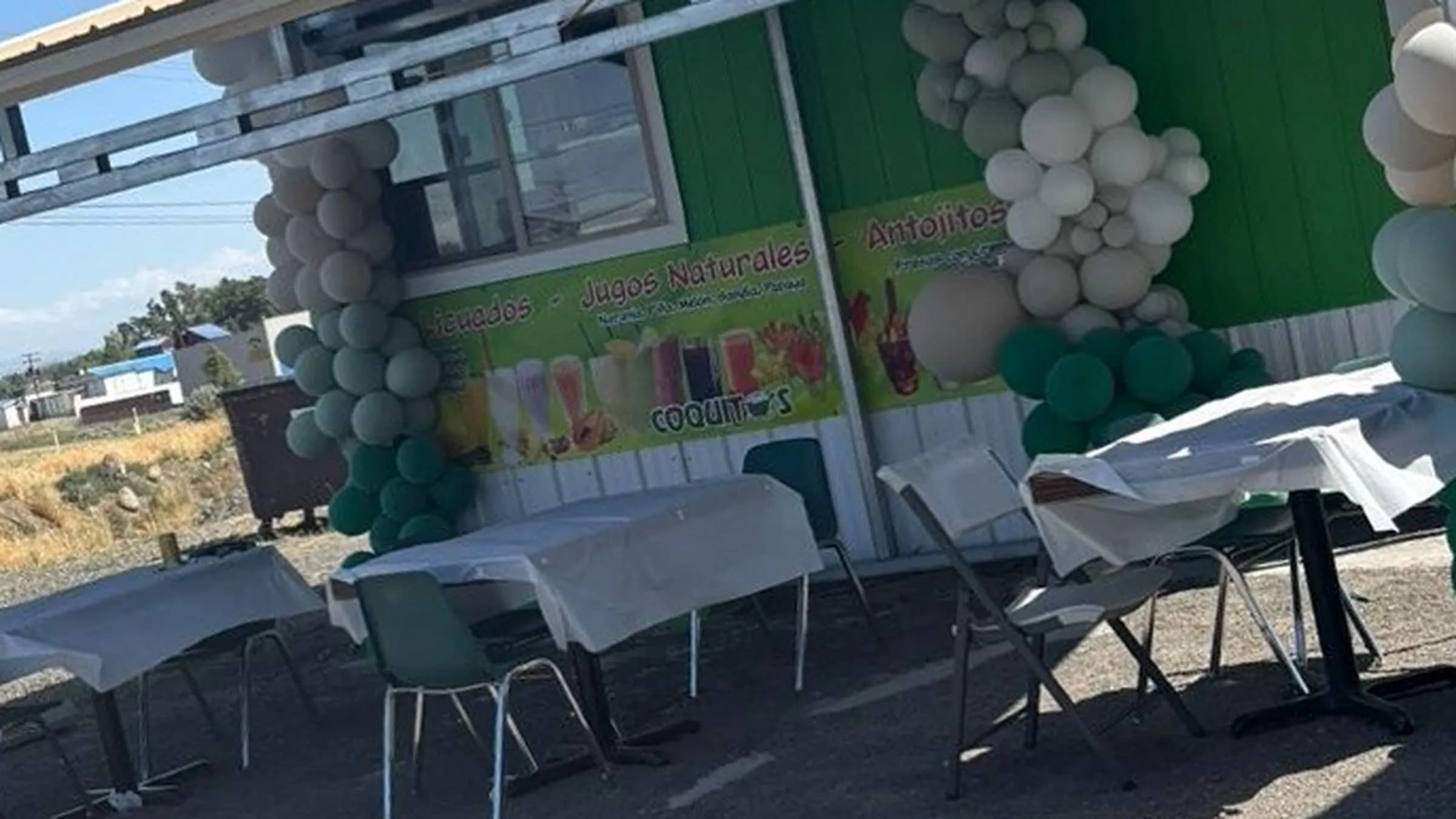 The green Coquitos Food truck in Hermiston with a balloon arch on opening day